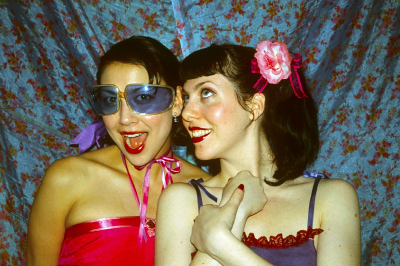 two young women in pink & blue, one wearing Blue Sunglasses, © Margaret Schnipper, photographer